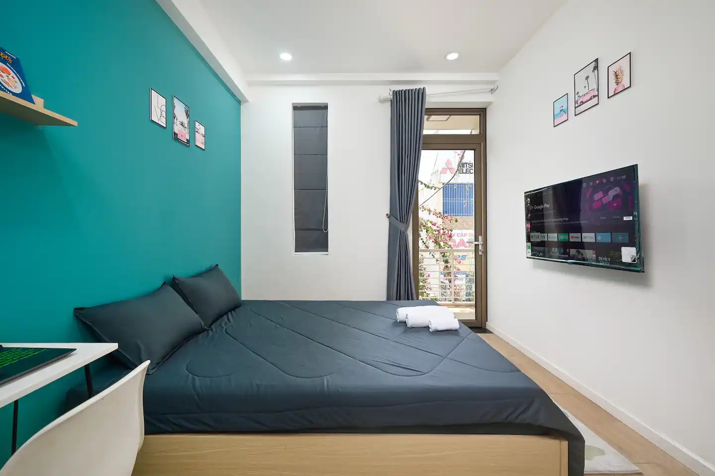 Studio 2.1 interior with queen bed, work desk and balcony door